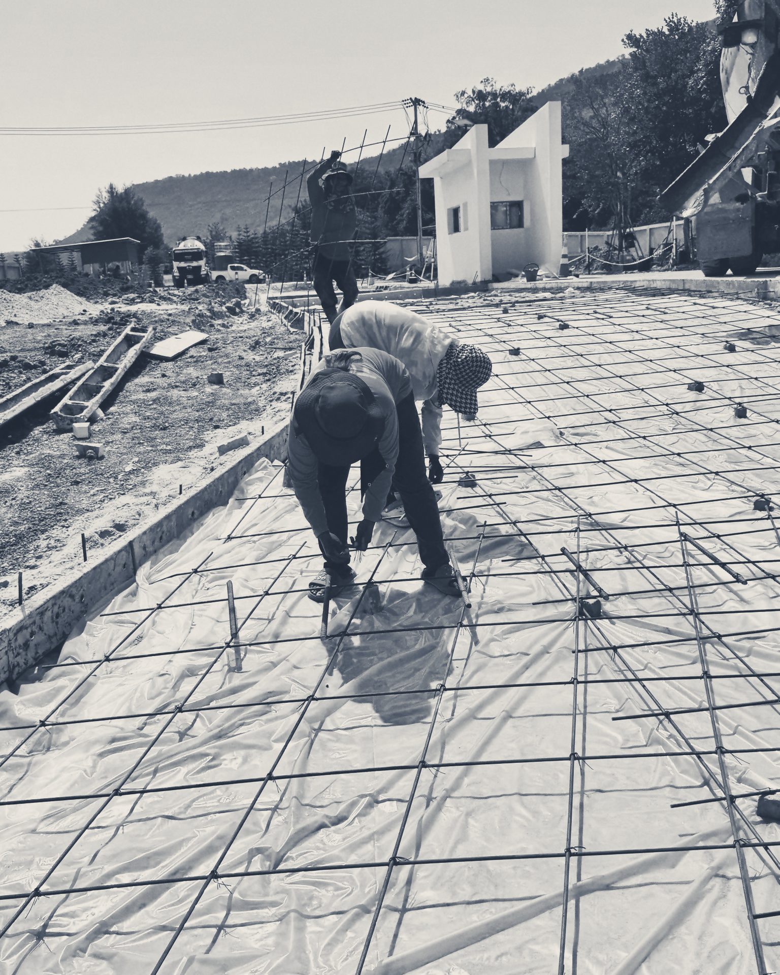 Crew in sun hats tying the slab mesh before a pour