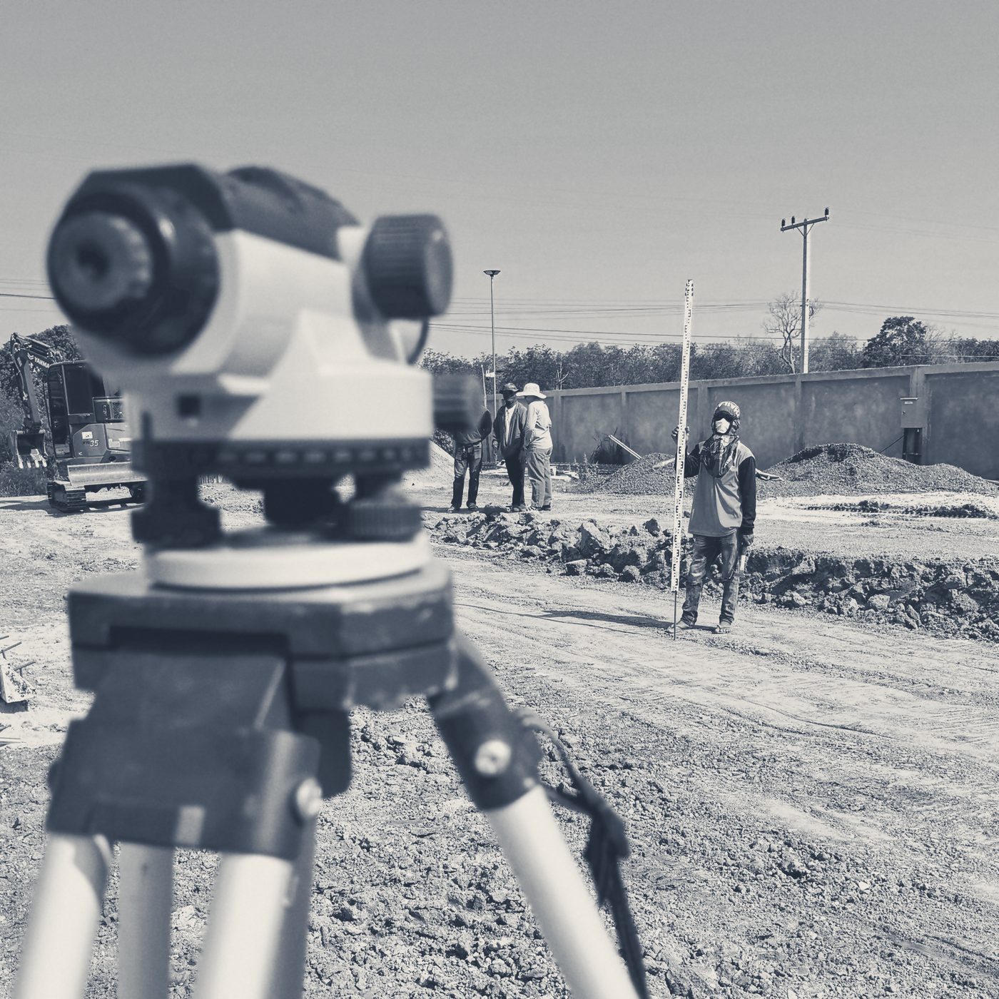 A survey level on its tripod over graded ground at the Main Gate site