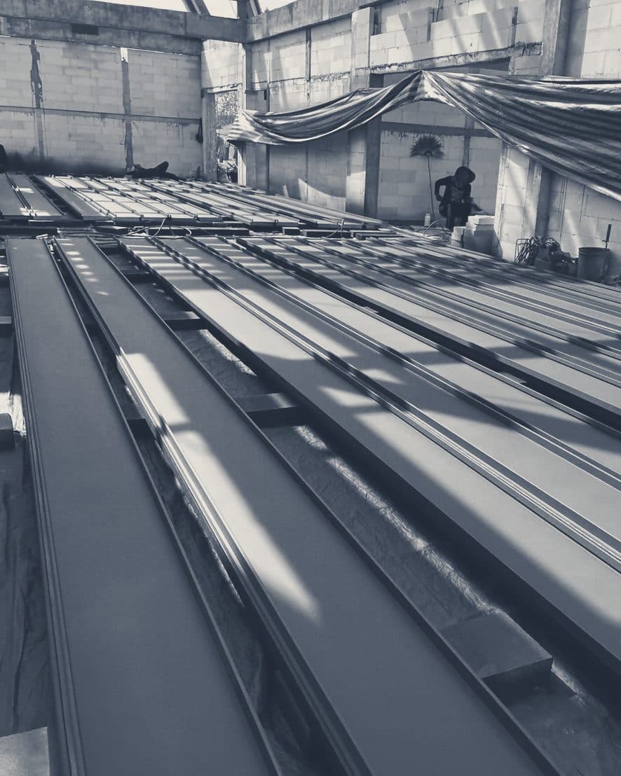 Standing-seam roof sheets laid out in rows on site.