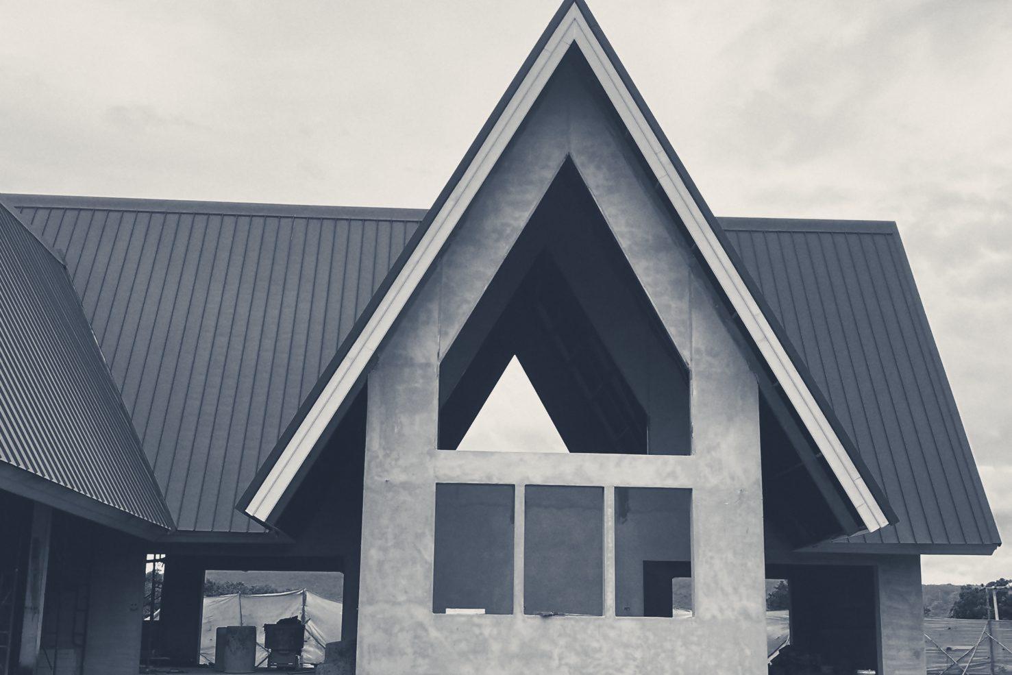 The main A-frame’s rendered gable under its steel roof