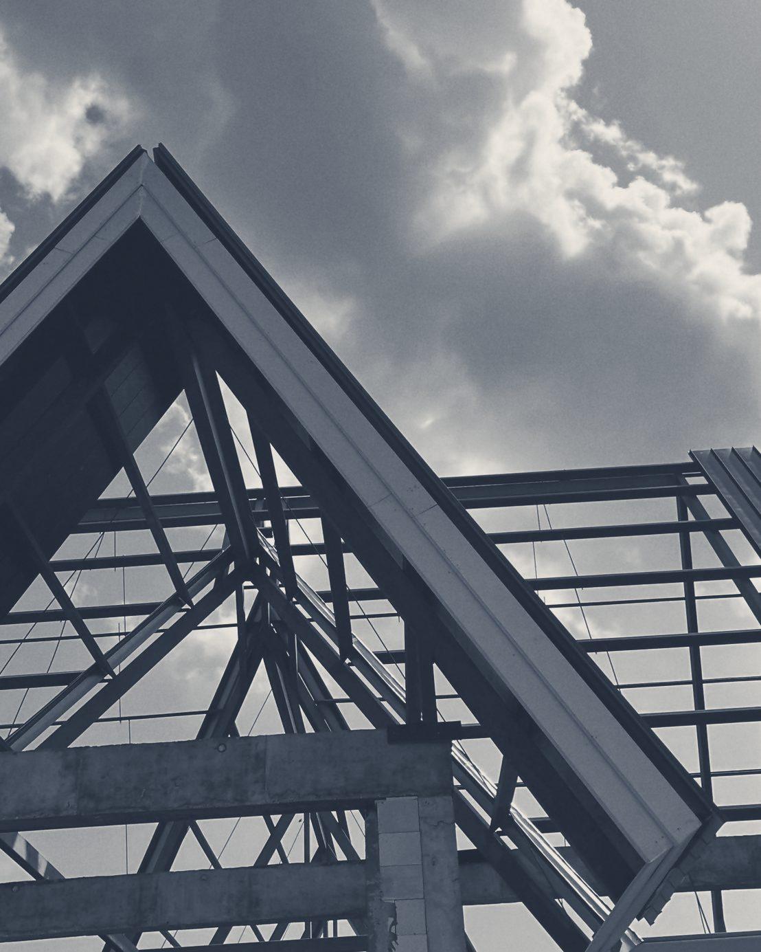 A steel gable frame against the clouds