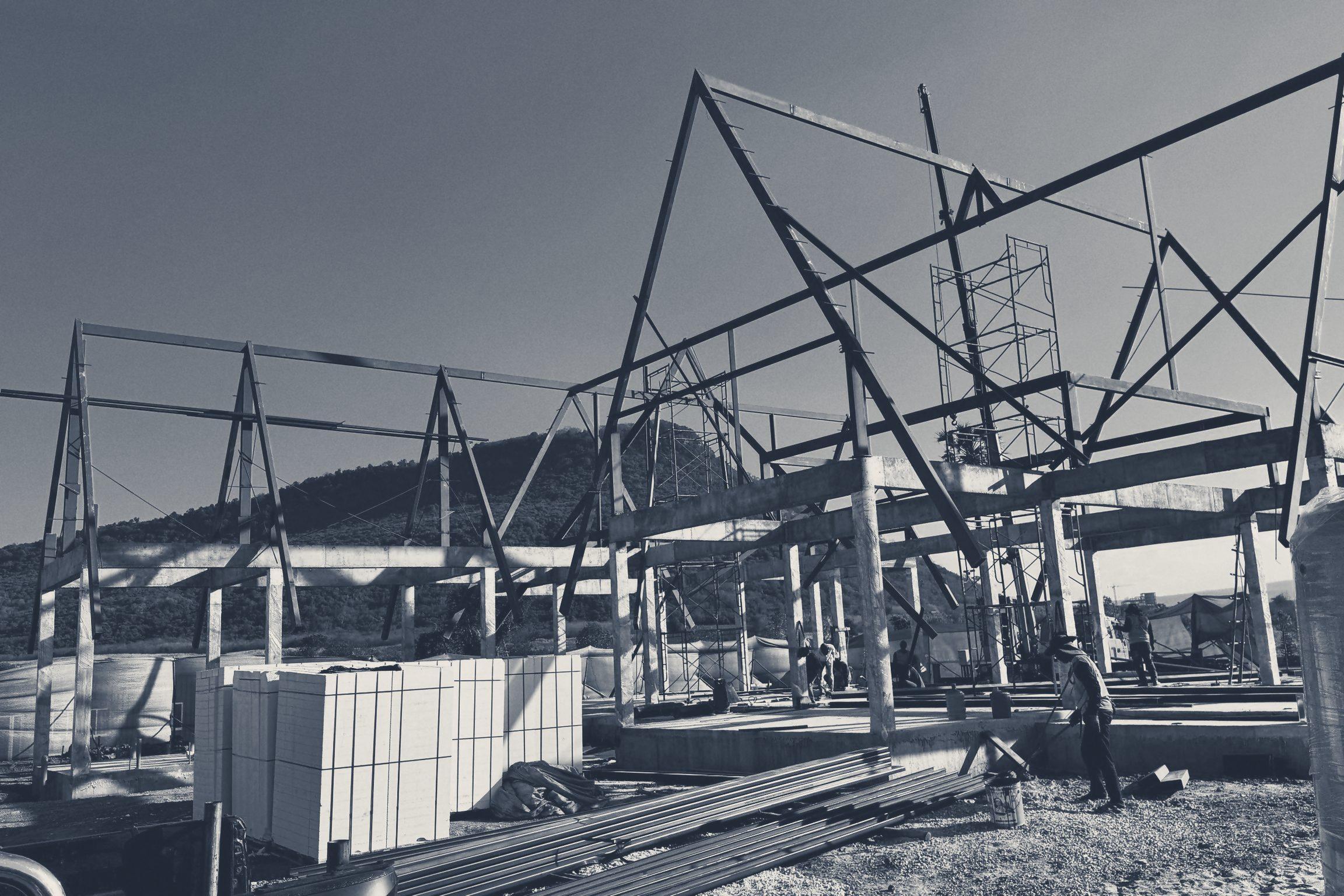 All three steel roof frames standing, with the hill behind