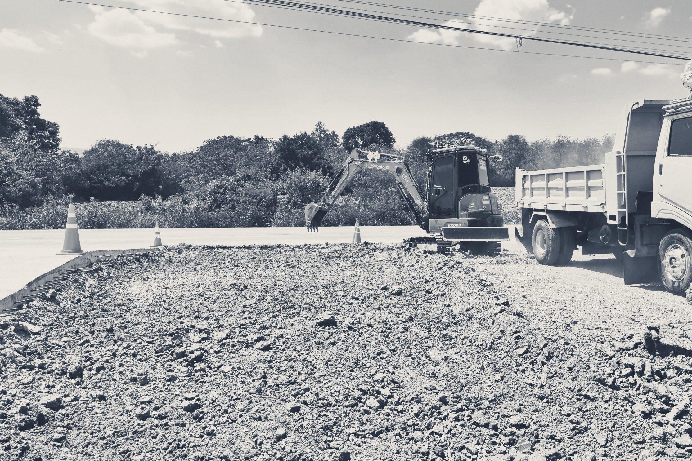 An excavator and a dump truck preparing the ground
