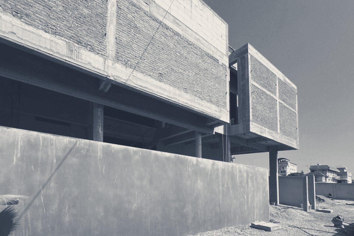 The two brick-clad volumes cantilevered over the ground floor, seen from the side yard