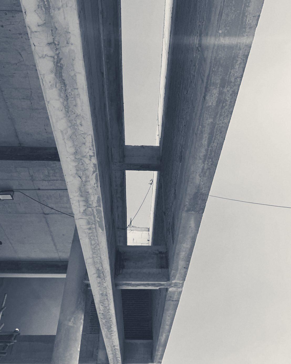 Looking up between the upper-floor beams to the sky