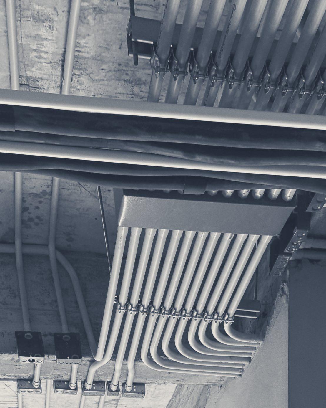 Yellow conduit runs gathered on the concrete ceiling before it is closed in