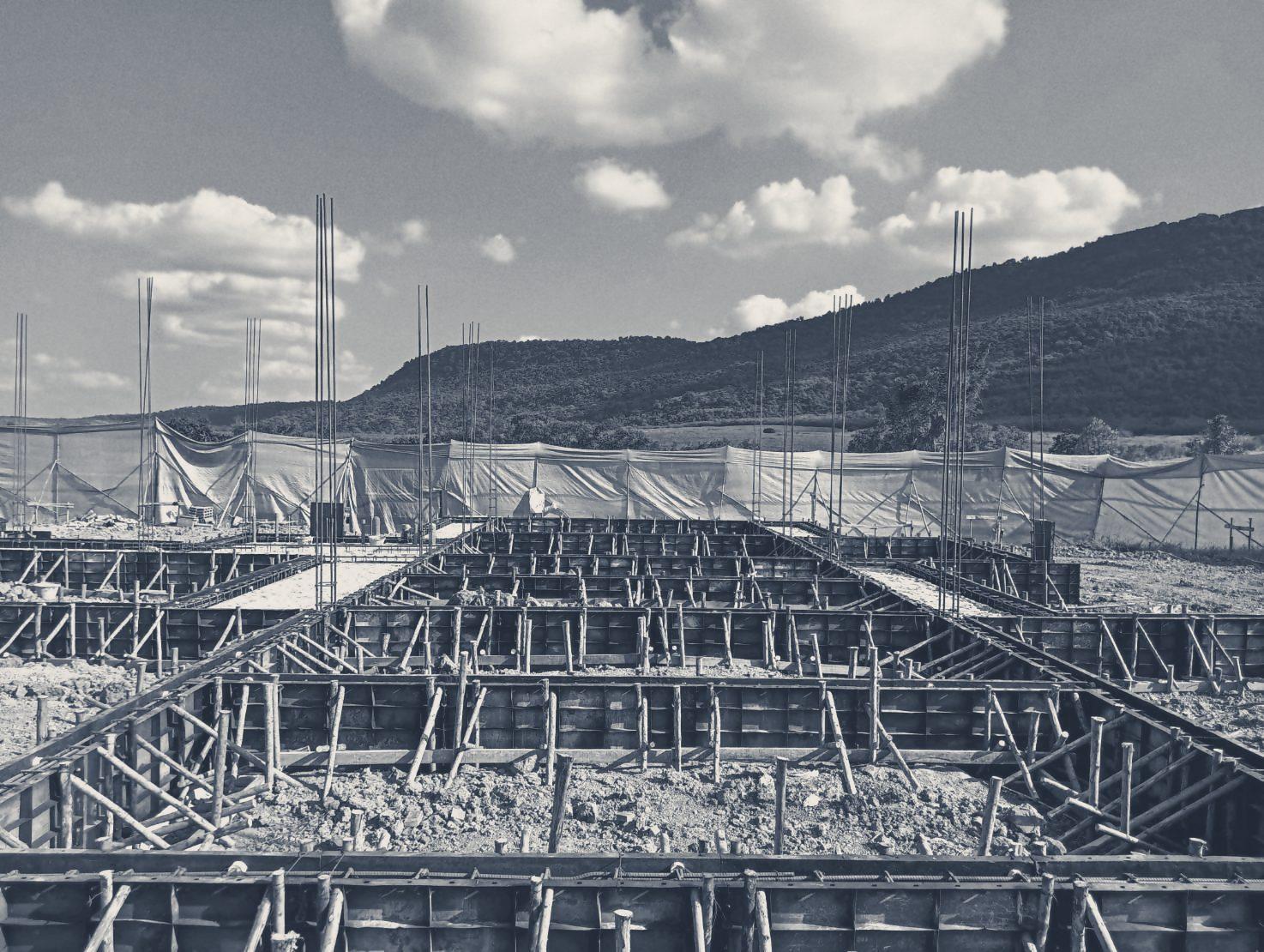 Footing formwork across the Club House site, with the hill and clouds behind